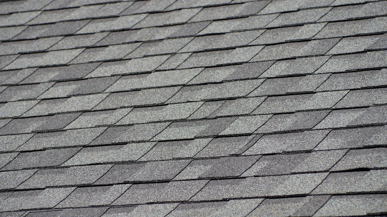 Overhead view of gray architectural asphalt shingles in overlapping rows