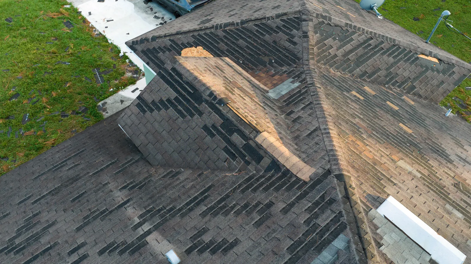 Bare wood showing where shingles were stripped from roof valleys and ridges